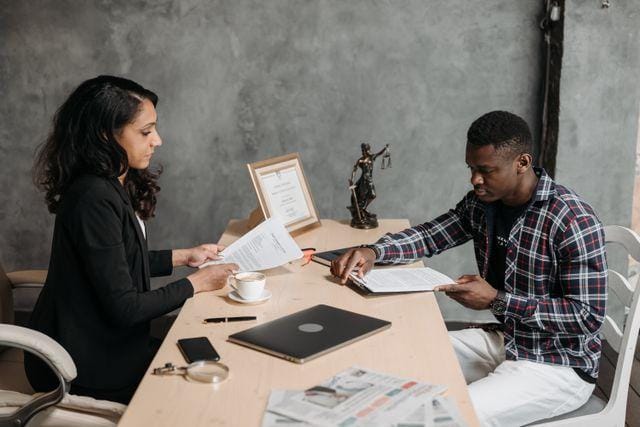 Property manager and applicant reviewing lease documents across a desk