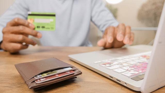 Tenant paying rent online with a credit card and laptop